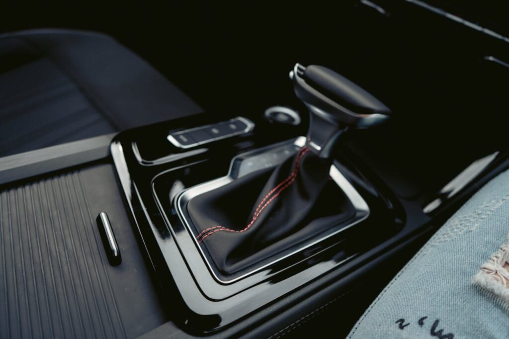 pexels-photo-2986849 Close-up of a luxury car's interior featuring a modern gear shift with leather and chrome accents.