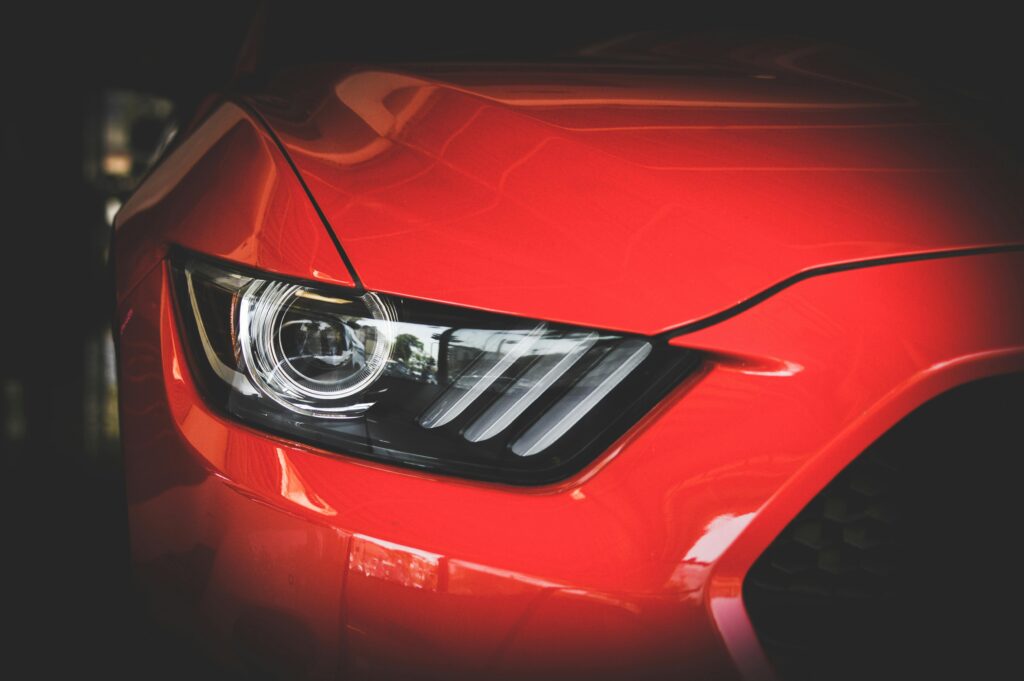 pexels-photo-638479-638479 Detailed view of a red Ford Mustang's headlight showcasing sleek automotive design.